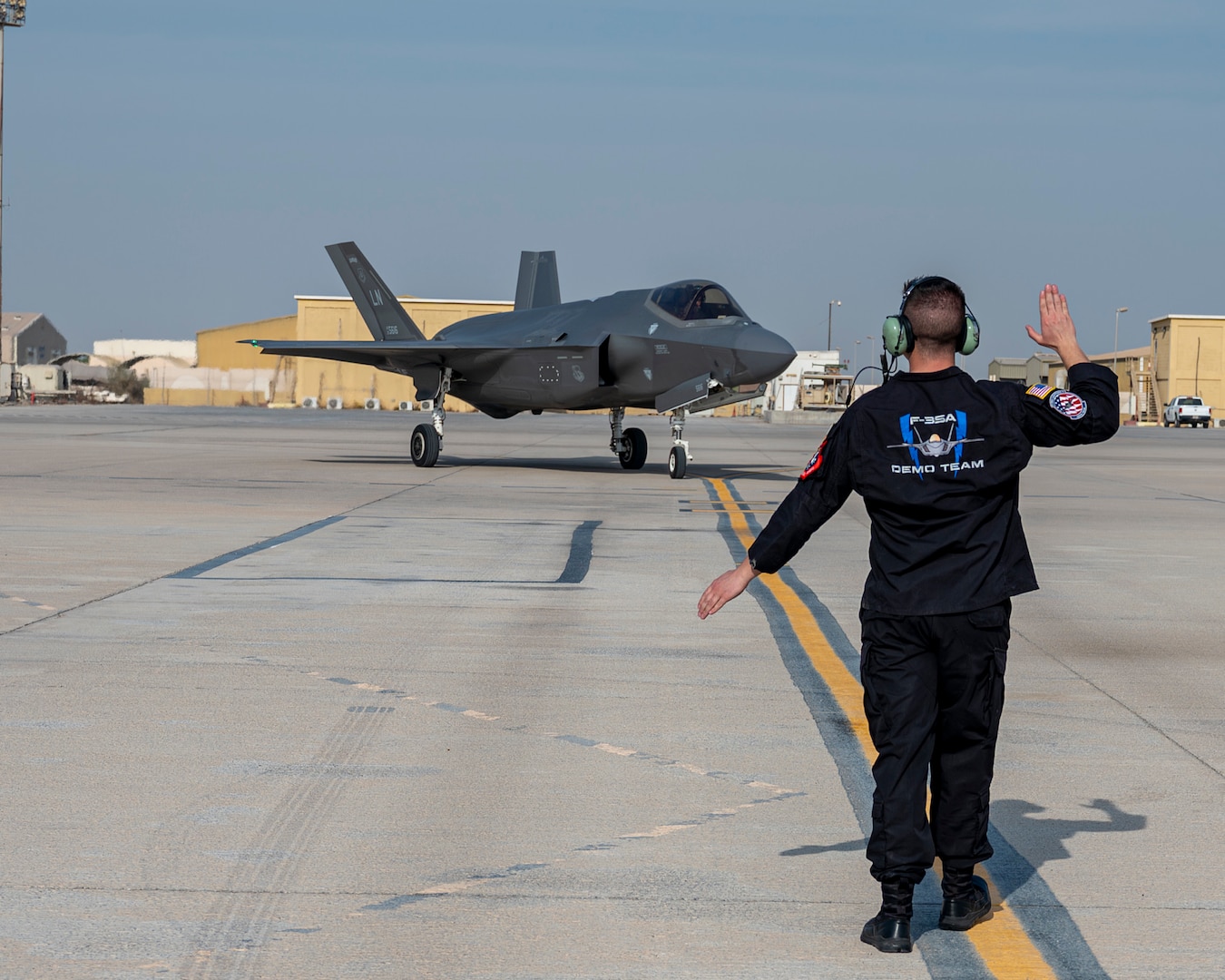 U.S. Air Force Staff Sgt. Jacob Sackett, a dedicated crew chief assigned to the F-35A Lightning II Demonstration Team, marshals an F-35A Lightning II after landing at Al Dhafra Air Base, United Arab Emirates, on Nov. 17, 2025. The team preformed at the Dubai Airshow to showcase the capabilities of the F-35A to nations around the globe. (U.S. Air Force photo by Staff Sgt. Nicholas Rupiper)