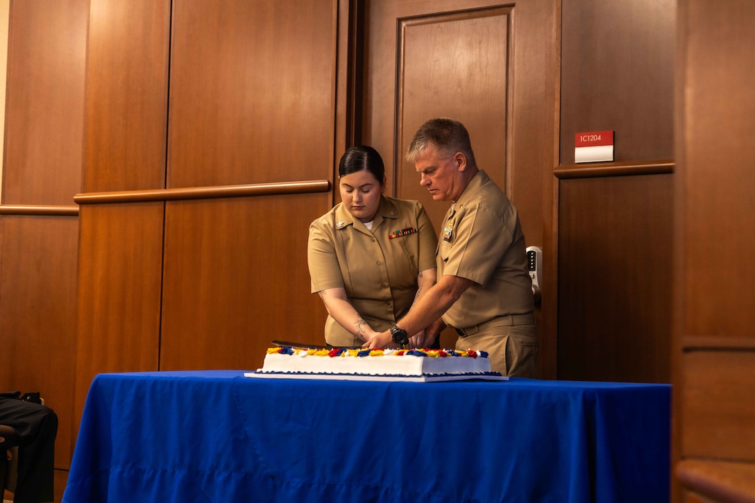 U.S. Navy Hospital Corpsman Second Class Nugent Rosanna, left, 4th Marine Division, Marine Forces Reserve, and Lt. Cmdr. Brad Johnson, operational planner and medical intelligence officer, Marine Forces South, cut the birthday cake during the Navy's 250th birthday ceremony at Marine Corps Support Facility New Orleans, Oct. 15, 2025. The birthday cake cutting ceremony between the oldest and youngest Sailors symbolizes the passing of knowledge and tradition from one generation to the next. (U.S. Marine Corps photo by Lance Cpl. Edward Spears)