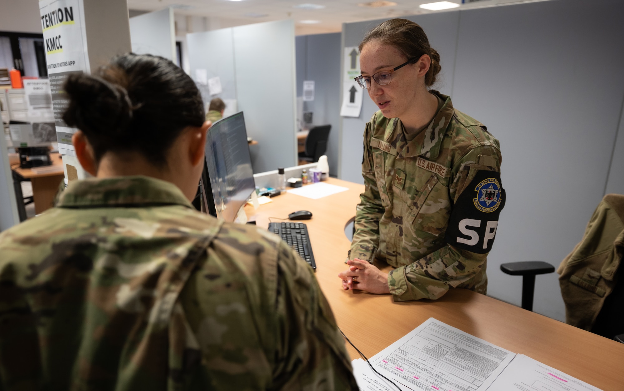 U.S. Air Force Senior Airman Hannah Lillund, 569th United States Forces Police Squadron vehicle registration clerk, answers the questions of Airman 1st Class Yessenia Secundino, 3rd Air Force commander’s executive administration technician, at Kapaun Air Station, Germany, Nov. 3, 2025. Lillund was off duty when she heard neighbors calling for help and provided aid that saved the life of a nine-month-old girl on Oct. 12. (U.S. Air Force photo by Senior Airman Jared Lovett)