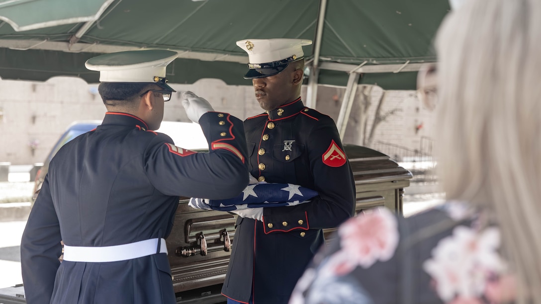 U.S. Marine Corps Cpl. Tris Torres, administrative specialist, Headquarters Battalion, Marine Forces Reserve, salutes a U.S. flag before it is presented to the family of Sgt. Frank Schmaltz at the Garden of Memories Funeral Home and Cemetery, Metairie, Louisiana, Oct. 13, 2025. Marine Corps Funeral Honors stands committed to ensuring that every Marine who has served receives the proper respects, serving as a final tribute to their life and a lasting demonstration of the nation's appreciation for their unwavering defense of our country, whether in times of conflict or peace. (U.S. Marine Corps photo by Lance Cpl. Van Hoang)