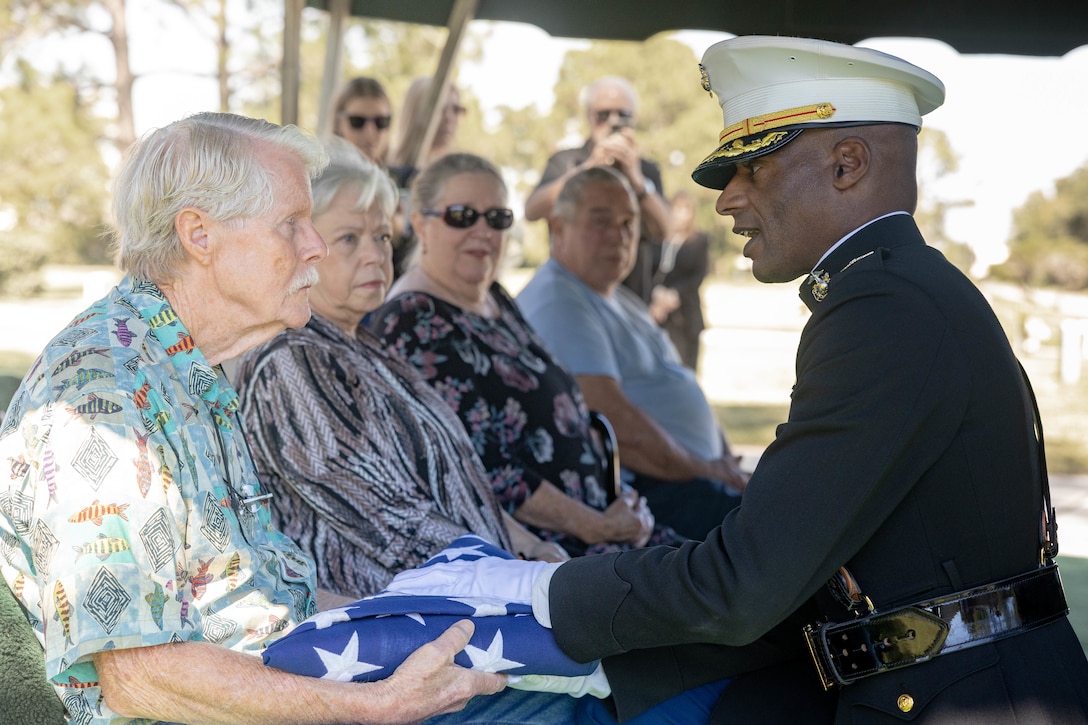 Wayne Bodker is presented with a U.S. flag by U.S. Marine Corps Col. Keith Dillard, logistician, Headquarters Battalion, Marine Forces Reserve, during the repatriation of U.S. Marine Corps Sgt. Frank Schmaltz at the Garden of Memories Funeral Home and Cemetery, Metairie, Louisiana, Oct. 13, 2025. The flag is a tribute of lasting importance to our service members, veterans and their families. (U.S. Marine Corps photo by Lance Cpl. Van Hoang)