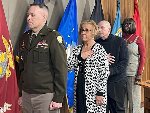DLA Troop Support Commander Army Brig. Gen. Sean P. Kelly. Stands at attention during the playing of the National Anthem before a retirement ceremony in Philadelphia on Nov 17. In order behind Kelly stand; Lynne DeSanto, David Friedman, and Renee Fitchett.