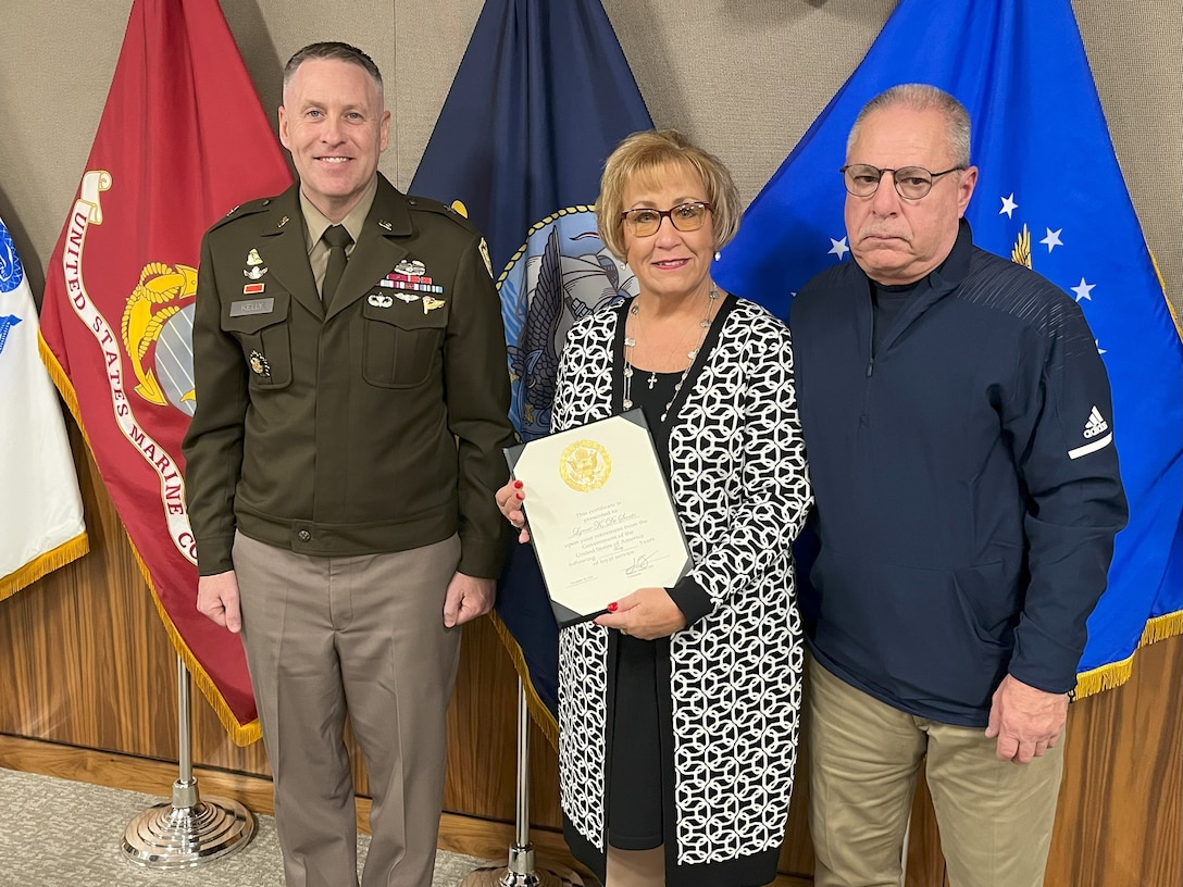 Lynne DeSanto stands with her spouse John, and DLA Troop Support Commander Army Brig. Gen. Sean P. Kelly during DeSanto’s retirement ceremony from Troop Support in Philadelphia on Nov 17.