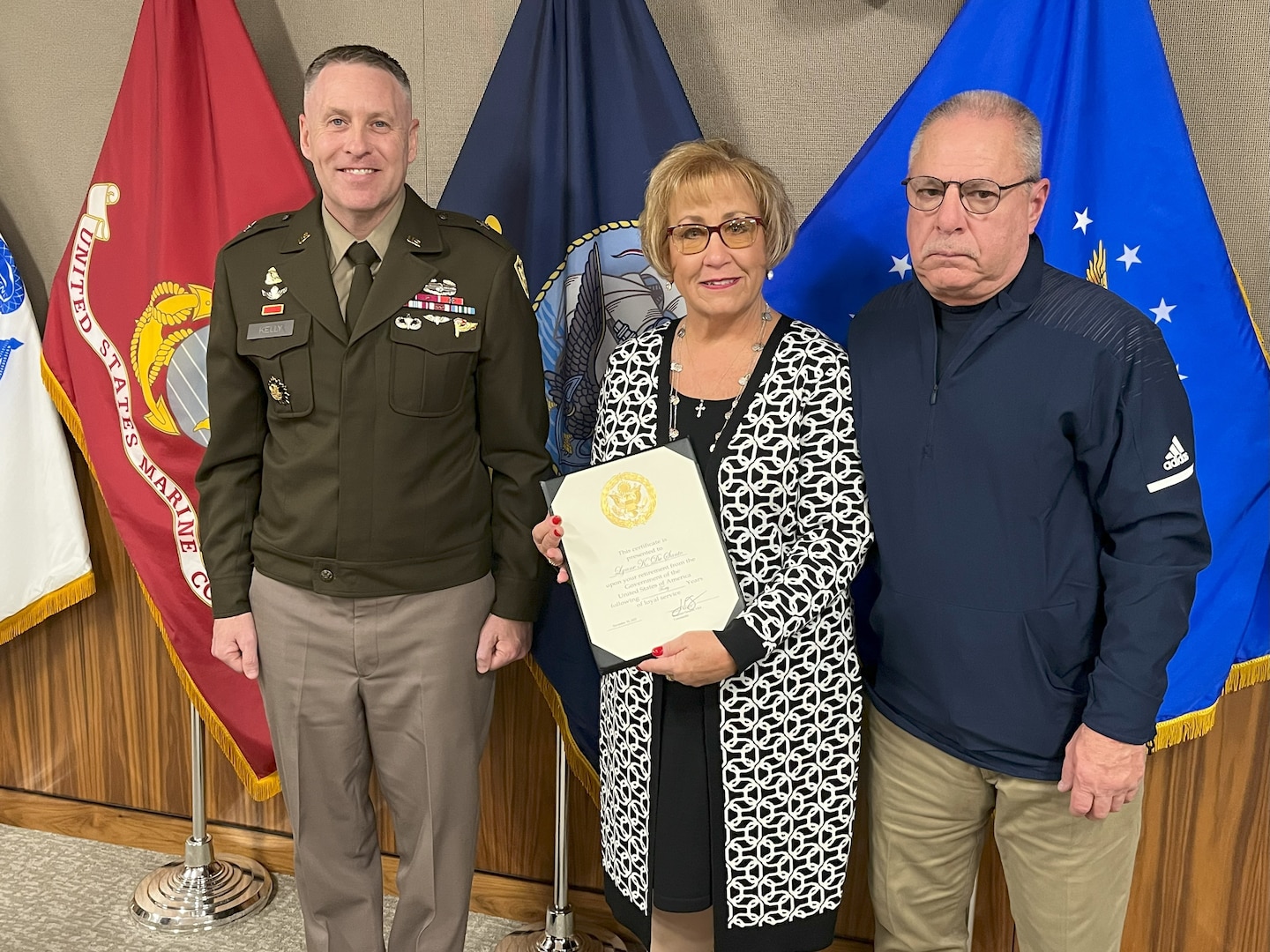Lynne DeSanto stands with her spouse John, and DLA Troop Support Commander Army Brig. Gen. Sean P. Kelly during DeSanto’s retirement ceremony from Troop Support in Philadelphia on Nov 17.