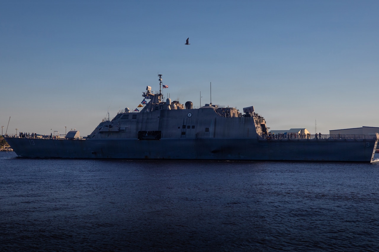 A military ship navigates a body of water.