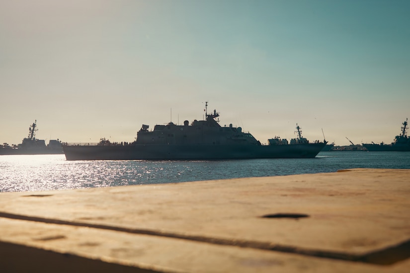 A group of military ships in a body of water.