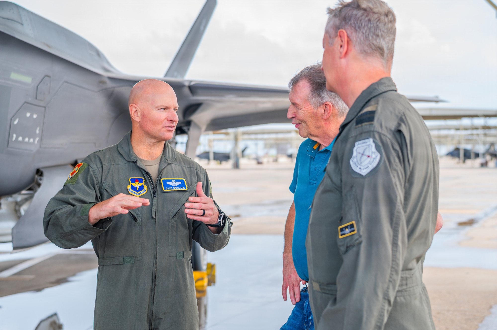 U.S. Air Force Brig. Gen. David Berkland (left), 56th Fighter Wing commander, speaks with Royal Netherlands Air and Space Force Brig. Gen. Marcel van Egmond (right), RNLASF Air Combat Command commander, and Brig. Gen. Peter Tankink (center), Joint Force Command Brunssum assistant chief of staff, on the flight line during a base visit