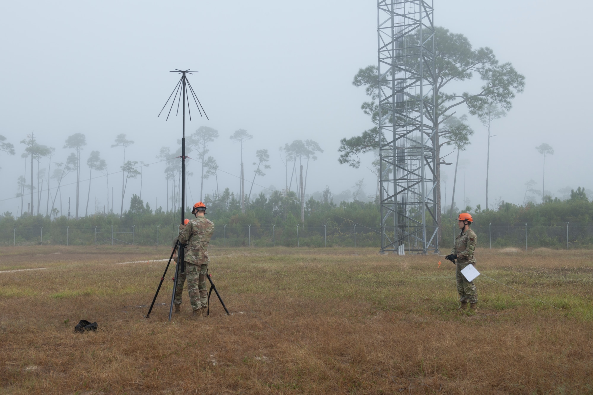 Three airmen assembling an antenna