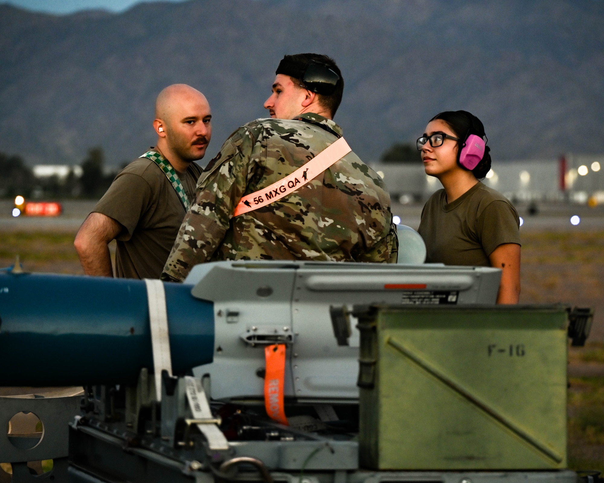 U.S. Air Force Staff Sgt. Cameron Canipe (left), Tech. Sgt. Wesley Boaz (middle), and Airman Mia Pule (right), 308th Aircraft Maintenance Unit aircraft armament systems specialists, participate in a Phase 2 Aircraft Generation exercise