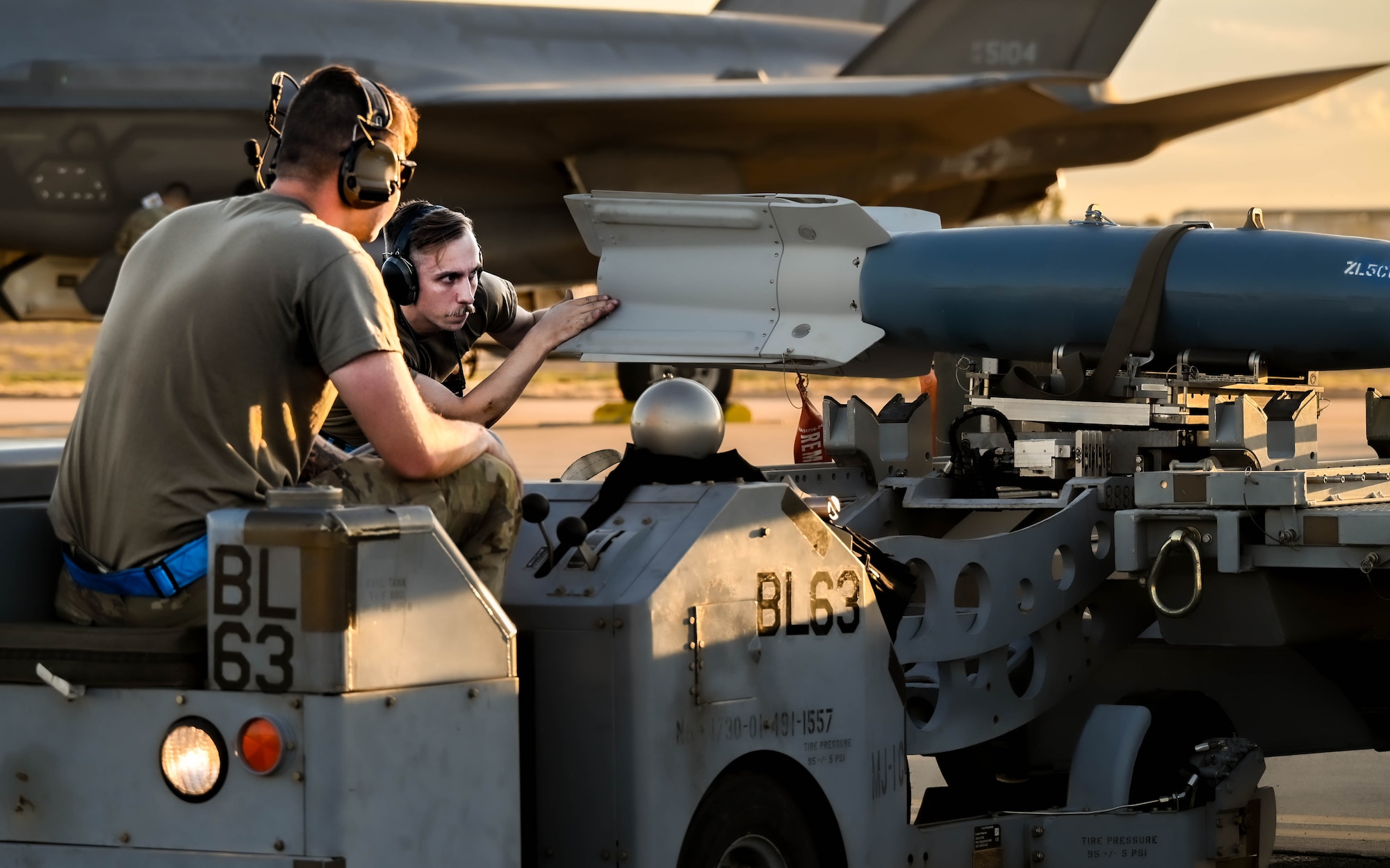 U.S. Air Force Senior Airman William Commeans (left) and Staff Sgt. Derek Rushing (right), 62nd Aircraft Maintenance Unit aircraft armament systems specialists, load ordnance onto an F-35A Lightning II as part of a Phase 2 Aircraft Generation exercise