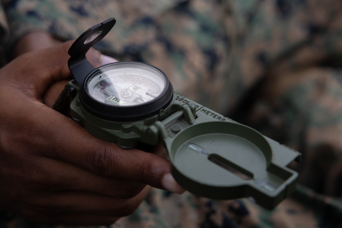 U.S. Marine Corps Cpl. Hassan Lee, a supply administrative clerk with Headquarters Battalion, Marine Forces Reserve, shoots an azimuth as part of a land navigation course during the Corporals Course 4-25 field exercise, Naval Air Station-Joint Reserve Base New Orleans, Belle Chasse, Louisiana, Sept. 26, 2025.  The field exercise tested the Marines’ leadership, decision making and small-unit tactics in a simulated environment. (U.S. Marine Corps photo by Cpl. Kanoa Thomas)