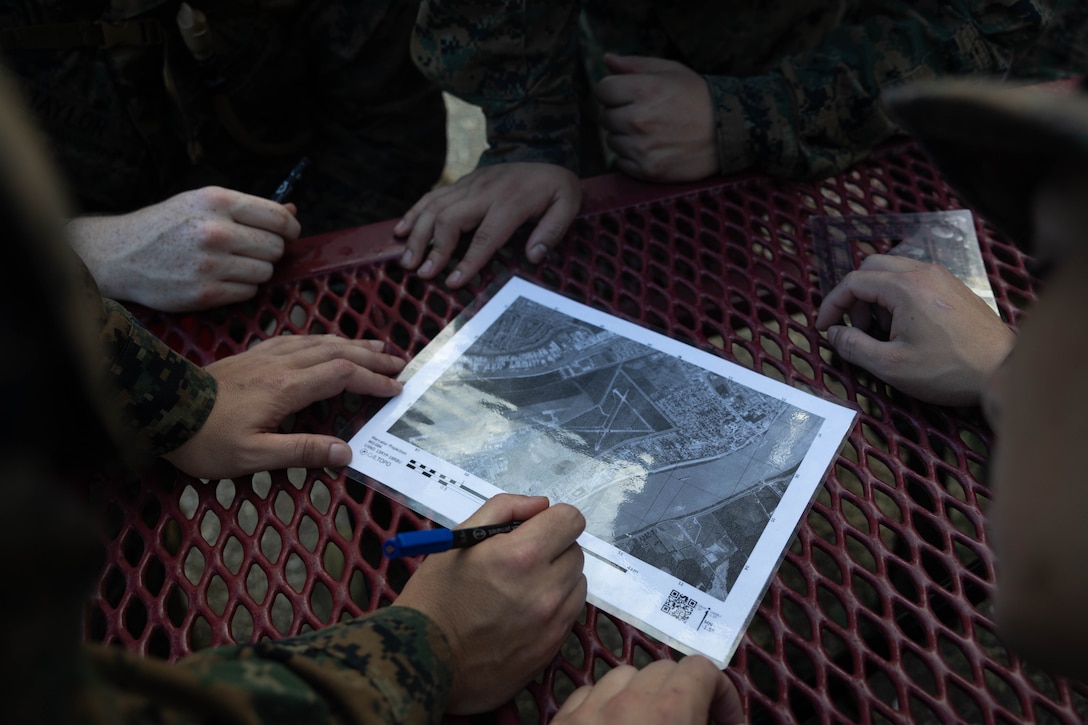 U.S. Marines with Headquarters Battalion, Marine Forces Reserve, plot points on a map during the land navigation course of the Corporals Course 4-25 field exercise, Naval Air Station-Joint Reserve Base New Orleans, Belle Chasse, Louisiana, Sept. 26, 2025.  The field exercise tested the Marines’ leadership, decision making and small-unit tactics in a simulated environment. (U.S. Marine Corps photo by Cpl. Kanoa Thomas