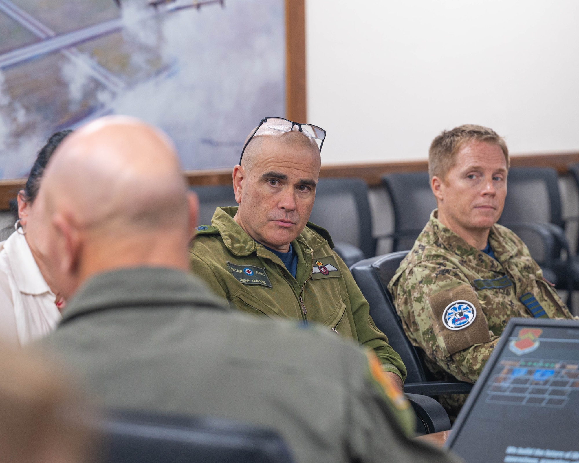 Royal Canadian Air Force Brig. Gen. Jeff Davis (center), 1st Canadian Air Division deputy commander force generation, listens to a mission brief during a base visit, Oct. 28, 2025, at Luke Air Force Base, Arizona.