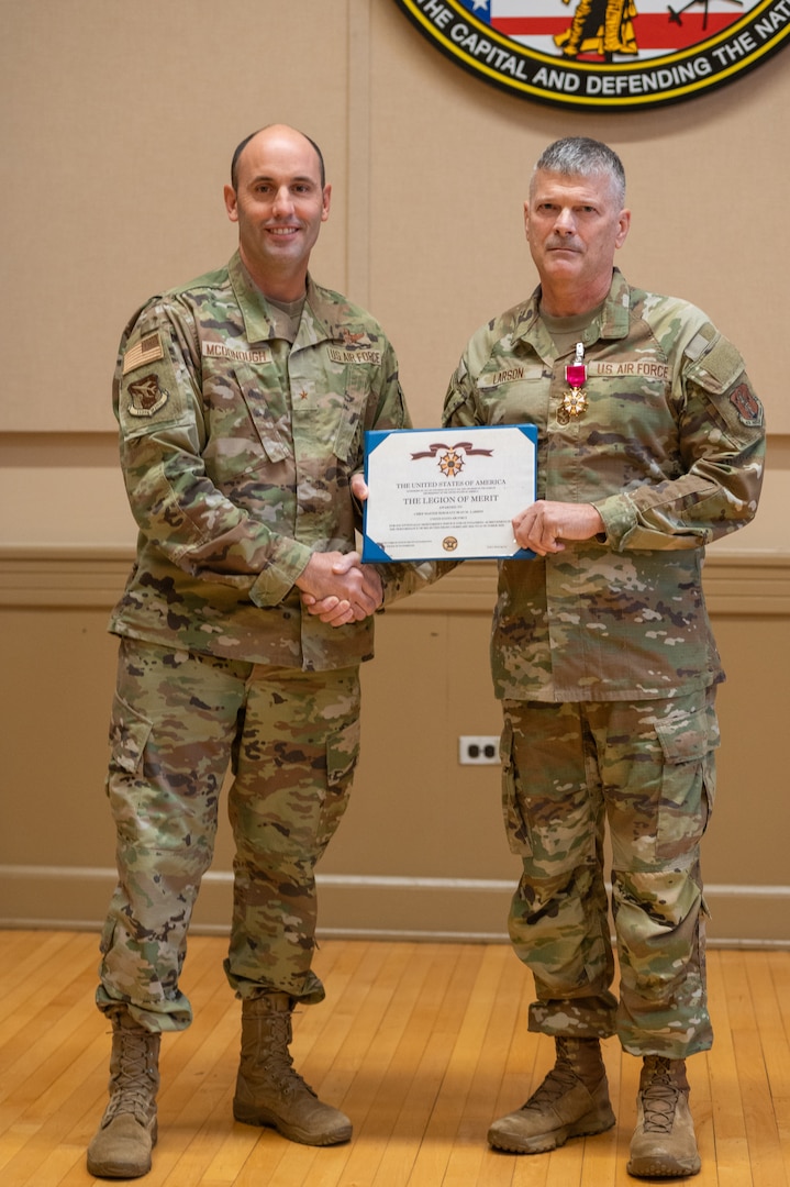 U.S. Air Force Brig. Gen. Matthew McDonough, commander of the 113th Air Wing, District of Columbia Air National Guard, left, presents the Legion of Merit medal to Chief Master Sgt. Sean. M. Larson during a change of responsibility ceremony transitioning the D.C. Command Chief Master Sgt. at the D.C. Armory in Washington, Nov. 9, 2025. Larson enlisted in the Air Force in 1986 and has held multiple high-profile assignments in active duty component, Iowa Air National Guard, and the D.C. Air National Guard.