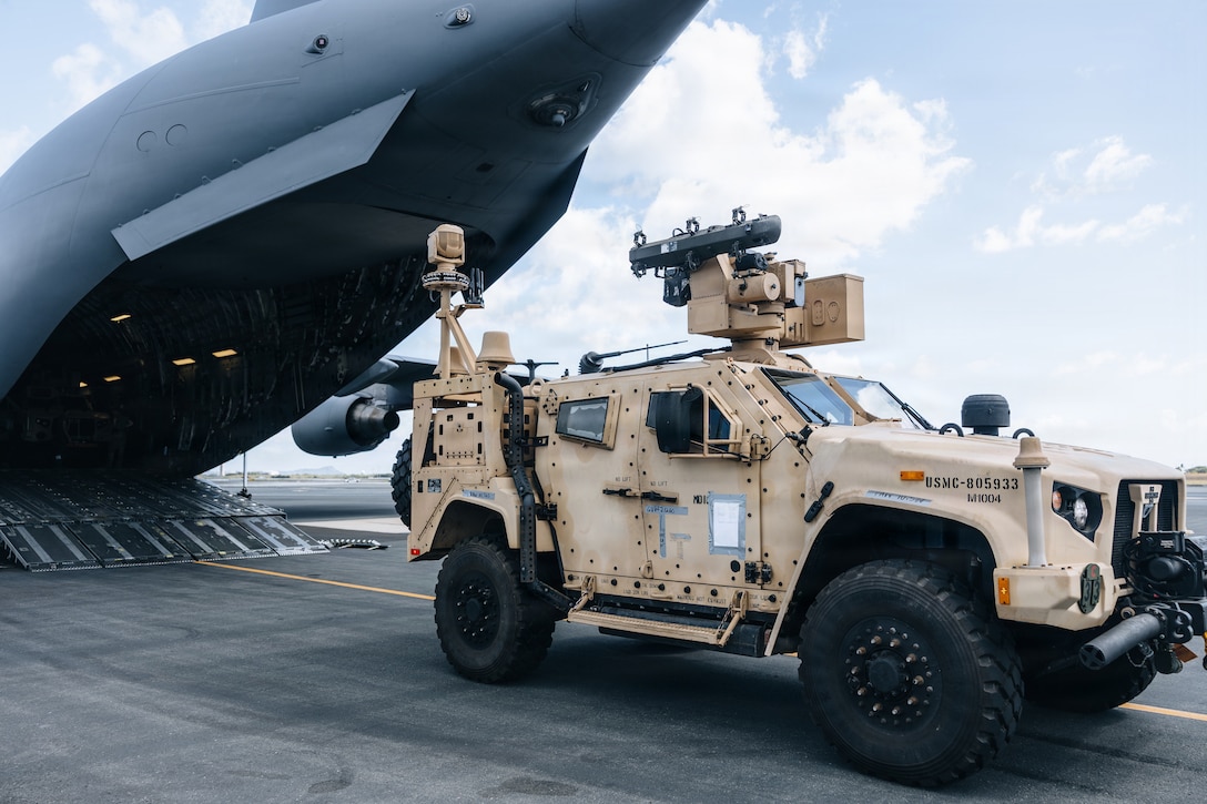 U.S. Airmen with 535th Airlift Squadron and Marines with 3rd Littoral Anti-Air Battalion, 3rd Marine Littoral Regiment, 3rd Marine Division, load a Marine Air Defense Integrated System, during a loading exercise onto a C-17A Globemaster III with the 535AS at Joint Base Pearl Harbor-Hickam, Hawaii, Oct. 24, 2025. The operation demonstrated 3d MLR’s ability to rapidly deploy MADIS capabilities across the Indo-Pacific, enhancing their capacity to counter aerial threats. (U.S. Marine Corps photo by Sgt. Jonathan Beauchamp)