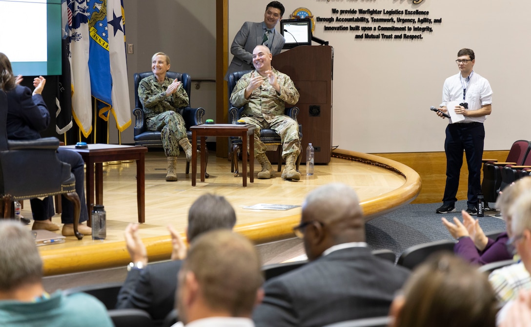 Two people laugh during a mock Jeopardy game.