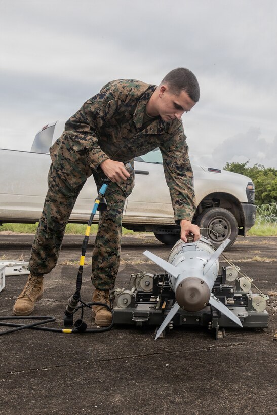 A U.S. Marine with Marine Fighter Attack Squadron (VMFA) 225, U.S. Marine Corps Forces, South, connects a GBU-54 Laser Joint Direct Attack Munition to a Common Munitions Bit Reprogramming Equipment system at Jose Aponte de la Torre Airport, Puerto Rico, Oct. 25, 2025. U.S. military forces are deployed to the Caribbean in support of the U.S. Southern Command mission, Department of War-directed operations, and the president’s priorities to disrupt illicit drug trafficking and protect the homeland. (U.S. Marine Corps photo)