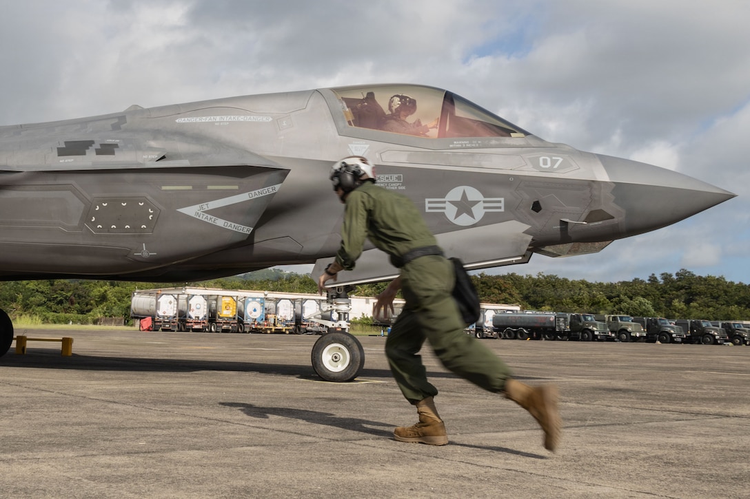 A U.S. Marine with Marine Fighter Attack Squadron (VMFA) 225, U.S. Marine Corps Forces, South, runs to remove a landing chock on an F-35B Lightning II assigned to VMFA-225 at Jose Aponte de la Torre Airport in Ceiba, Puerto Rico, Oct. 29, 2025. U.S. military forces are deployed to the Caribbean in support of the U.S. Southern Command mission, Department of War-directed operations, and the president’s priorities to disrupt illicit drug trafficking and protect the homeland. (U.S. Marine Corps photo)