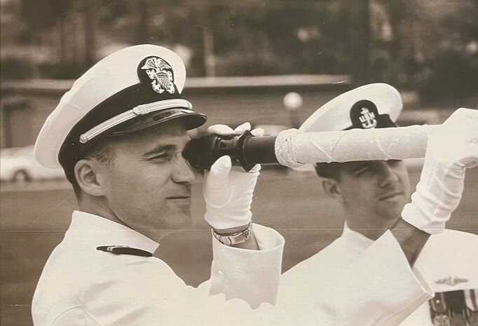 SAN DIEGO, Calif. – Dan Hogan holds a telescope during a change of command ceremony. Today, Hogan plays a crucial role in the development and enhancement of software that guarantees the submarines are always prepared for their missions. (Dan Hogan/Courtesy Photo)
