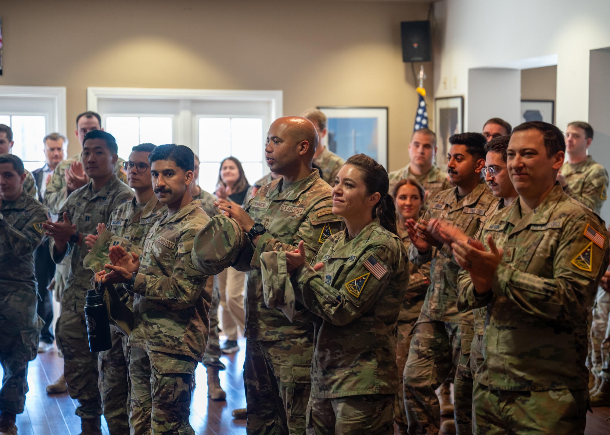 U.S. Air Force Chief Master Sgt. Malcolm Summers II, Space Launch Delta 30 senior enlisted airman, and U.S. Space Force Chief Master Sgt. Shannan Sanchez, SLD 30 senior enlisted leader, clap at a patching ceremony.
