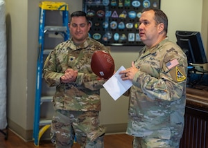 U.S. Space Force Col. Dorian Hatcher, Space Launch Delta 30 deputy commander, stands while holding a football next to Lt. Col. Ralph Salazar, 2nd Range Operations Squadron commander.