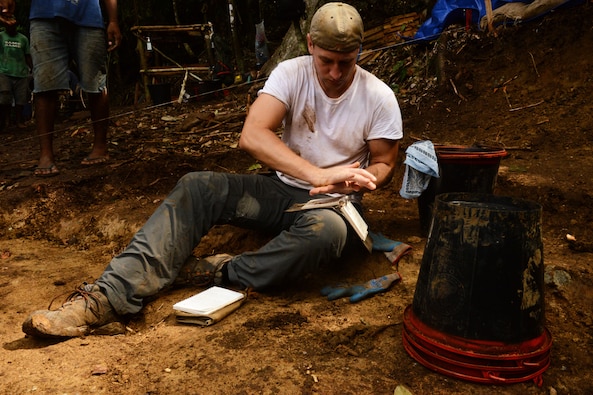 Dr. Kyle McCormick, Defense POW/MIA Accounting Agency anthropologist, studies a soil sample in an excavation unit for a DPAA recovery mission Guadalcanal Province, Solomon Islands, Nov. 18, 2016.