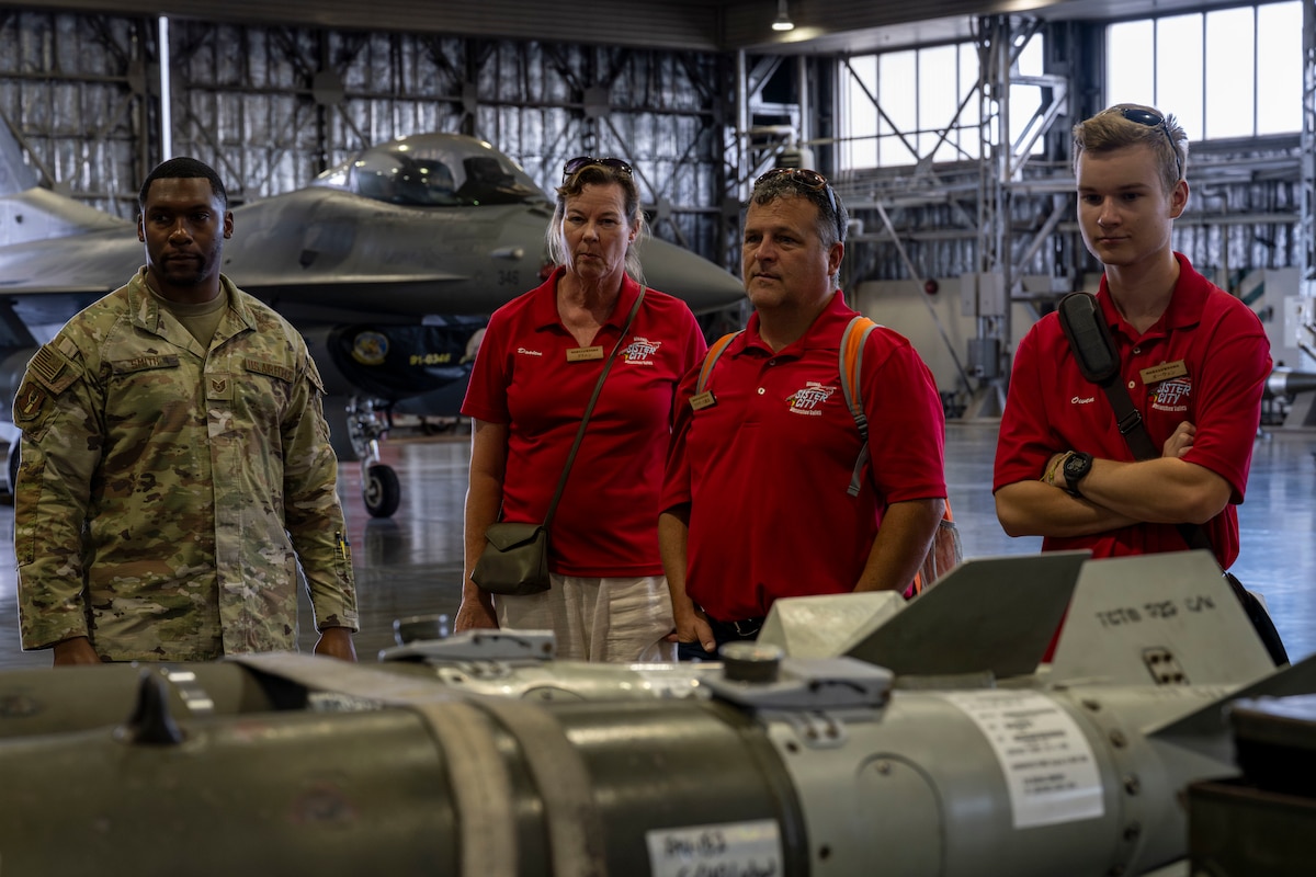 Members of the Wenatchee Valley, Washington sister city delegation look at F-16 Fighting Falcon munitions while their function is explained by members of the 35th Maintenance Group at Misawa Air Base, Japan, Oct. 3, 2025. Delegates from Wenatchee visit Misawa City annually, highlighting the legacy of community relations initiated by the historic Miss Veedol flight in 1931, the first non-stop flight across the Pacific Ocean starting at Sabishiro Beach, Misawa and landing in East Wenatchee. (U.S. Air Force photo by Senior Airman Patrick Boyle)