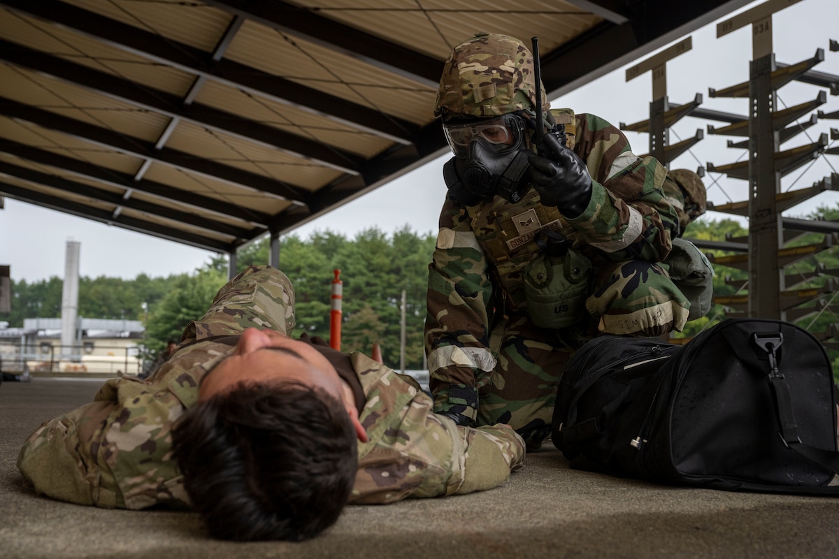 A U.S. Air Force Airman assigned to the 35th Logistics Readiness Squadron examines a casualty actor during a post attack reconnaissance sweep during Beverly Sunrise 26-01 at Misawa Air Base, Japan, Oct. 16, 2025. The mass casualty exercise strengthened the 35th Fighter Wing’s ability to respond to large-scale emergencies, ensuring Airmen can preserve life and maintain mission capability under pressure. (U.S. Air Force photo by Senior Airman Patrick Boyle)