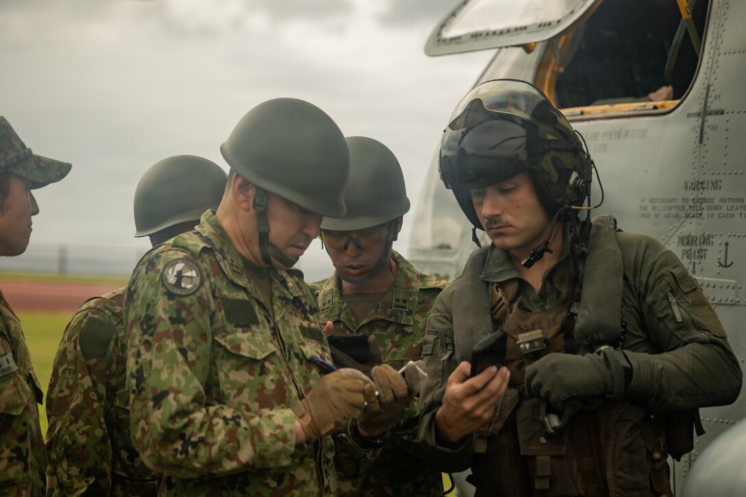 U.S. Marine Corps Sgt. Scott Stadlman, an avionics technician with Marine Heavy Helicopter Squadron 462, Marine Aircraft Group 36, 1st Marine Aircraft Wing, and a Japan Ground Self-Defense Force member work together at a forward arming and refueling point on Yonaguni, Japan, Oct. 27, 2025. The FARP training enhanced interoperability and strengthened the ability of U.S. Marines and the JGSDF to control and defend key maritime terrain. Stadlman is a native of New Jersey. (U.S. Marine Corps photo by Lance Cpl. Ryan Sotodavila)