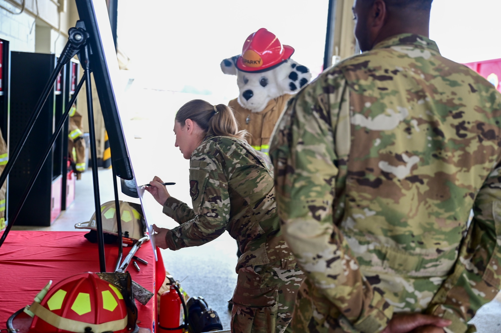 A woman signs a poster board.