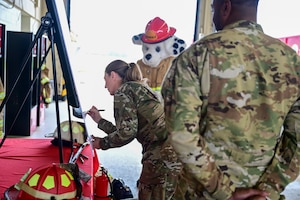 A woman signs a poster board.