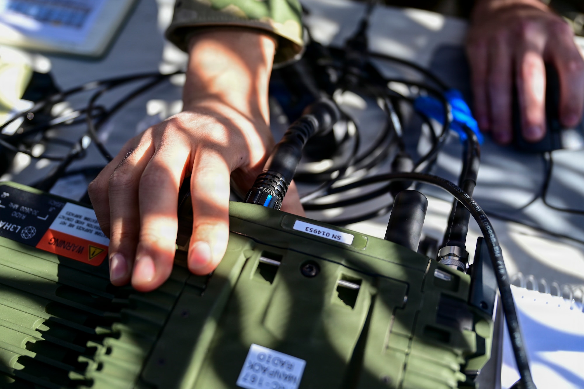 A hand touches controls on a radio.