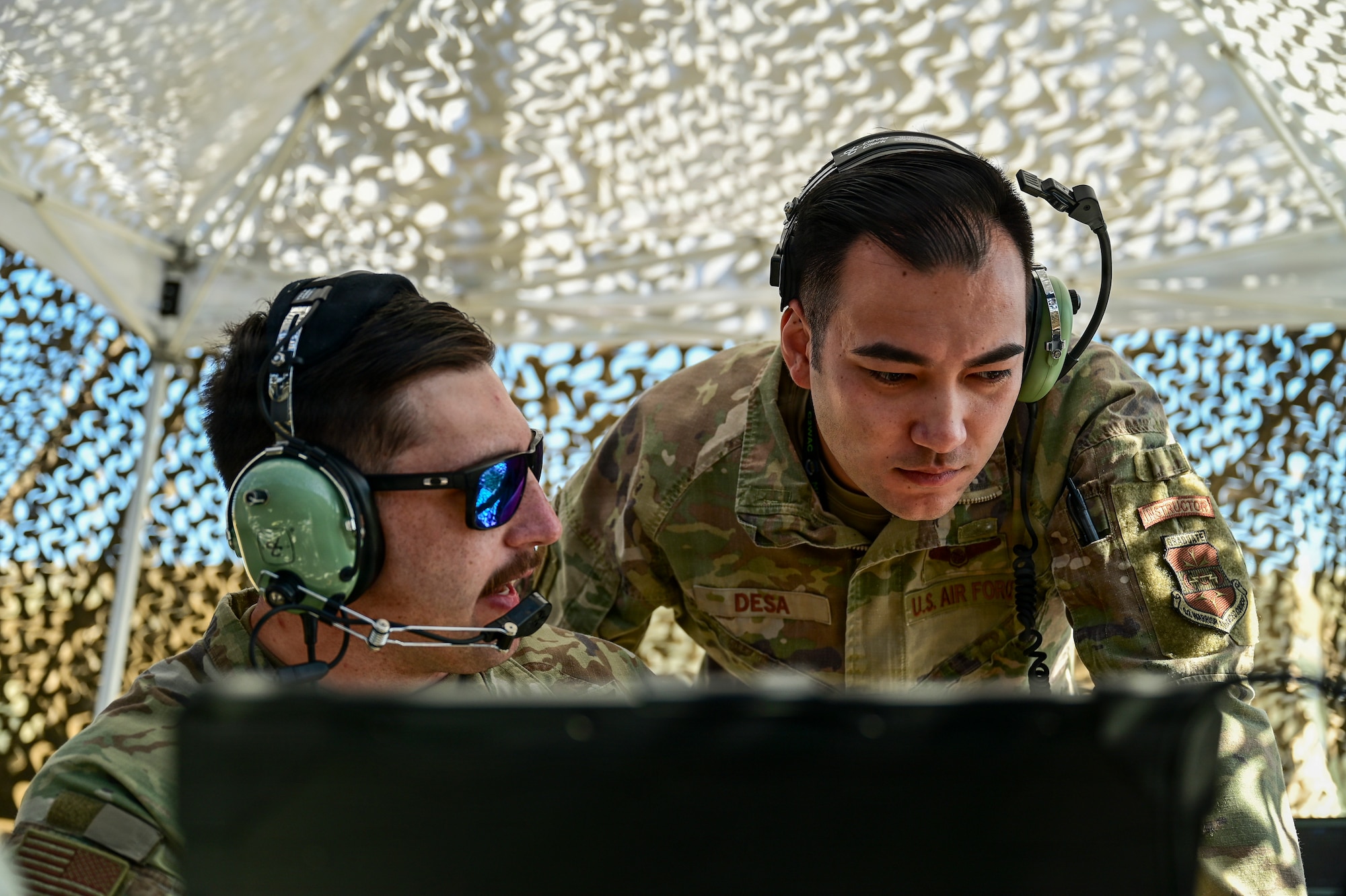 Two men work on a computer.