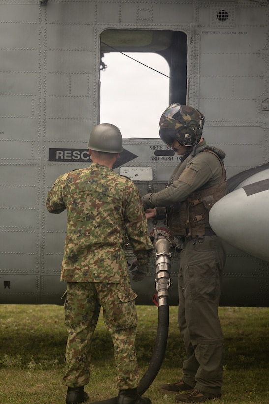 U.S. Marine Corps Sgt. Scott Stadlman, an avionics technician with Marine Heavy Helicopter Squadron 462, Marine Aircraft Group 36, 1st Marine Aircraft Wing, and a Japan Ground Self-Defense Force member refuel a CH-53E Super Stallion at a forward arming and refueling point on Yonaguni, Japan, Oct. 27, 2025. The FARP training enhanced interoperability and strengthened the ability of U.S. Marines and the JGSDF to control and defend key maritime terrain. Stadlman is a native of New Jersey. (U.S. Marine Corps photo by Lance Cpl. Ryan Sotodavila)