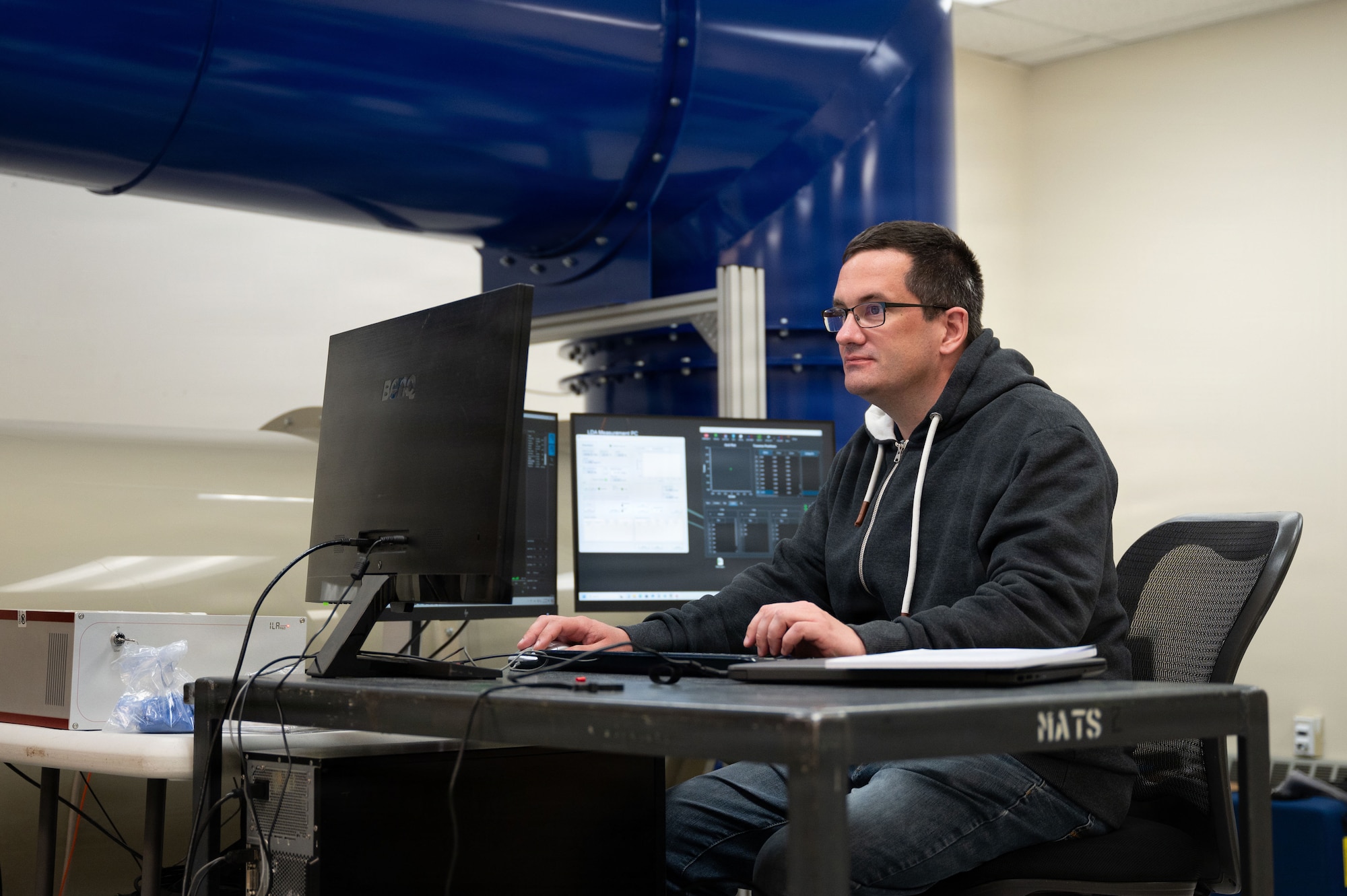 photo of a lab wind tunnel operator testing equipment.