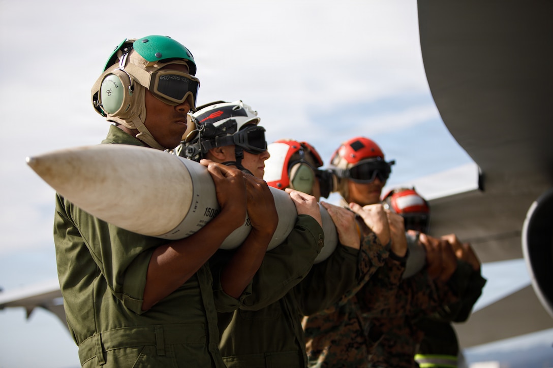 U.S. Marines with Marine Fighter Attack Squadron (VMFA) 232, and Marine Aviation Logistics Group Squadron (MALS) 12, both with, Marine Aircraft Group 12, 1st Marine Air Wing, transport an AIM-120C air-to-air missile during an ordnance off-load at Marine Corps Air Station Iwakuni, Japan, Nov. 5, 2025. MALS-12 and VMFA-232 conducted ordnance revolutions to off-load air-to-air missiles to showcasing rapid-response and air superiority in support of keeping a free and open Indio-Pacific. (U.S. Marine Corps photo by Sgt. Peter Rawlins)