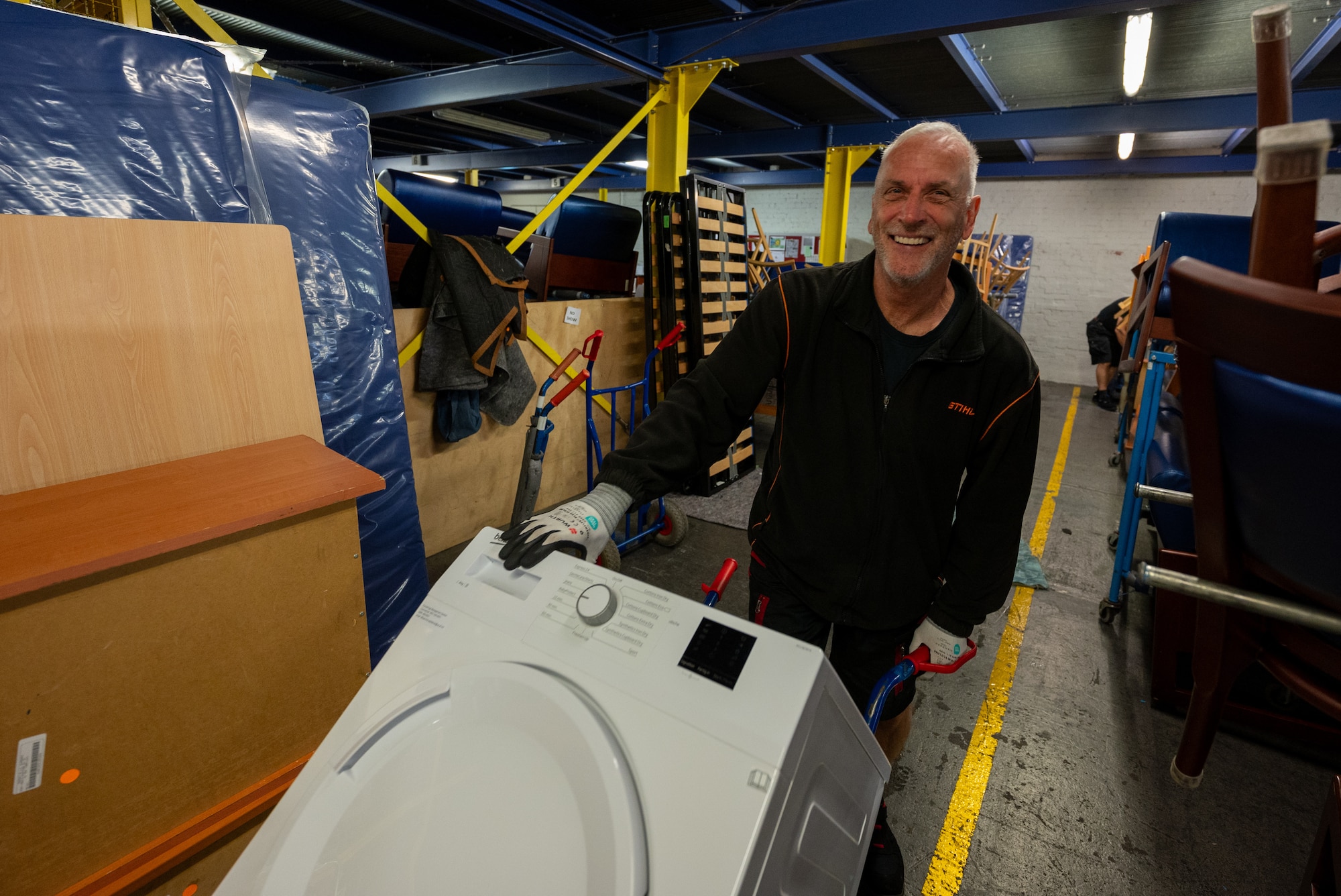 Juergen Klan, 86th Civil Engineer Squadron material handler and driver takes a washing machine to a transportation vehicle at Einsiedlerhof Air Station, Germany, July 25, 2025. The 86th Civil Engineer Group maintains infrastructure and facilities across multiple installations within the Kaiserslautern Military Community, supporting the largest American military community outside the United States. (U.S. Air Force photo by Senior Airman Jared Lovett)
