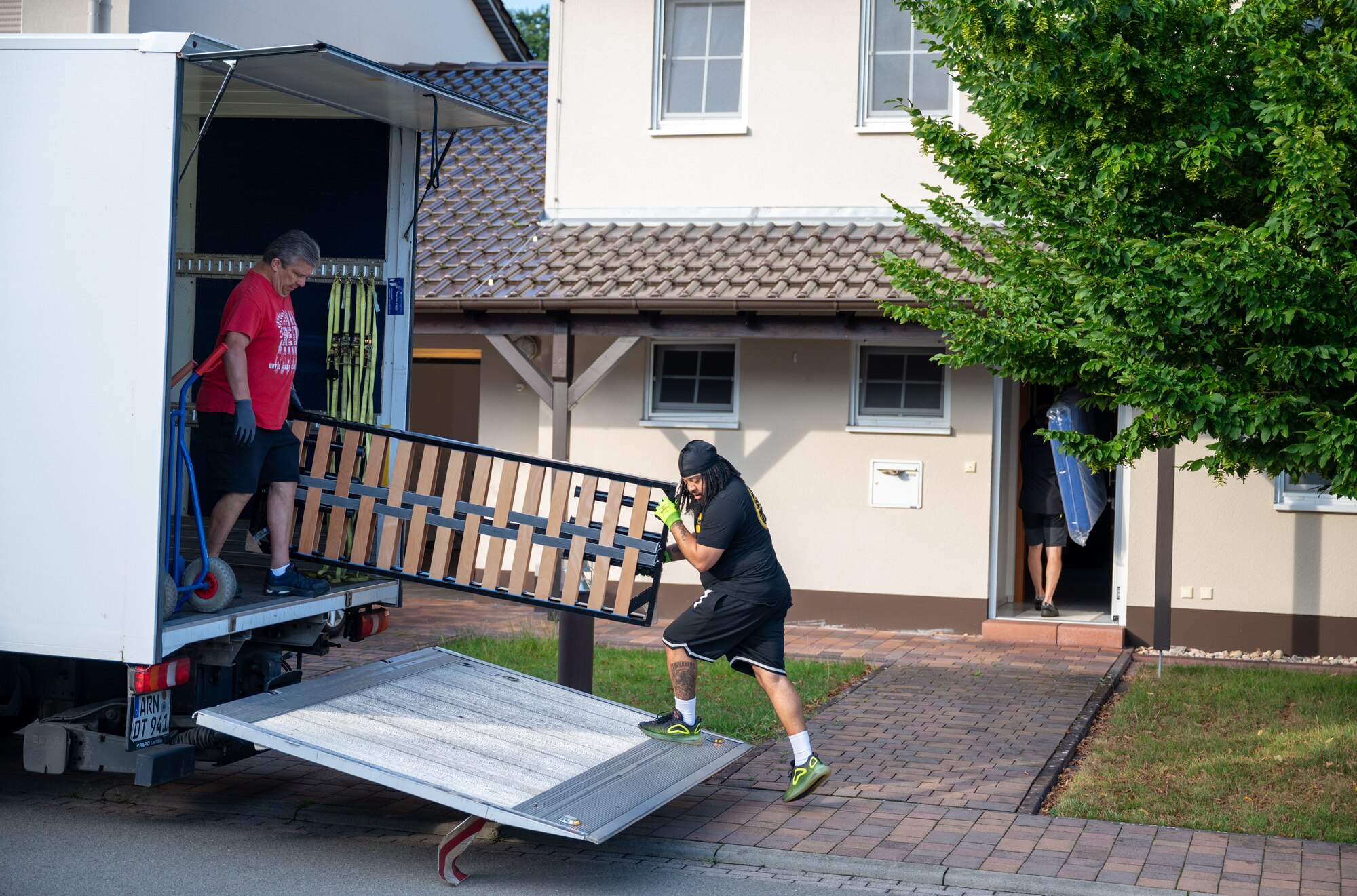 Dan Gilligan and Sean Buckner, 86th Civil Engineer Squadron material handlers, move furniture into on-base housing at Kapaun Air Station, Germany, July 25, 2025. The 86th Civil Engineer Group ensures operations by maintaining critical infrastructure that supports Airmen, families and mission partners across the Kaiserslautern Military Community. (U.S. Air Force photo by Senior Airman Jared Lovett)