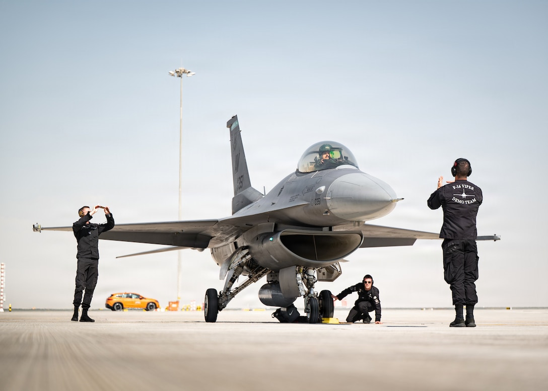 A U.S. Air Force F-16C Fighting Falcon assigned to the 31st Fighter Squadron at Aviano Air Base, Italy, is marshalled by U.S. Air Force F-16 Viper Demonstration Team crew chiefs for the Dubai Airshow at Dubai, United Arab Emirates, Nov. 12, 2025. The VDT performs at airshows across the U.S. and abroad, showcasing the capabilities of the F-16 to a global audience. (U.S. Air Force photo by Staff Sgt. Steven Cardo)