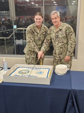 Logistics Specialist 2nd Class Caycee Dawley, the most junior Sailor in attendance, proudly shares the ceremonial cut with U.S. Navy Captain Douglas Pegher, a distinguished senior leader, during the Navy's 250th birthday celebration.