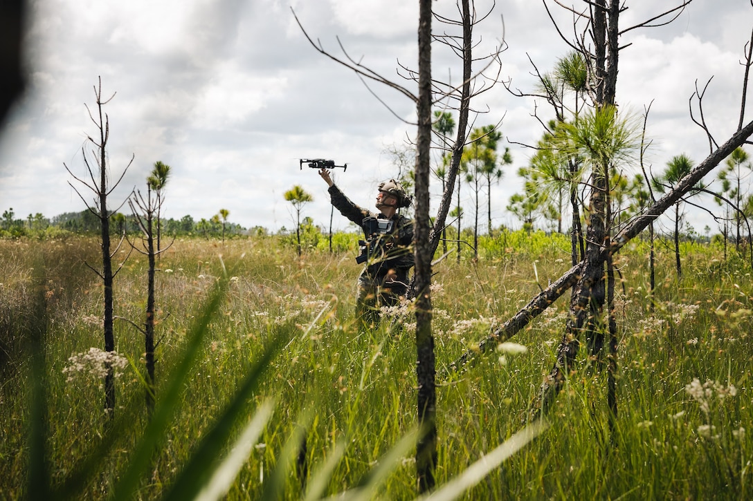 U.S. Marine Corps Cpl. Hunter Zenoni, a precision weapons repairer, attack drone operator, and maintenance chief with the Marine Corps Attack Drone Team, Weapons Training Battalion, Training Command, retrieves a Parrot Anafi drone during a joint full mission profile airfield seizure demonstration at the National Drone Association Drone Crucible in Florida, Sept. 23, 2025. The MCADT participated in the Drone Crucible with other teams from across the joint force to showcase capabilities and exchange tactics, techniques, and procedures to advance first-person view attack drone and other small unmanned aircraft systems employment. (U.S. Marine Corps photo by Cpl. Joshua Barker)
