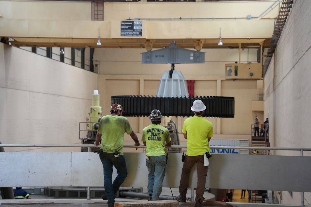 Andritz contractors overseeing bridge crane operation as a massive rotor is carefully moved toward them during the turbine generator rehabilitation project at Old Hickory Powerhouse on the Cumberland River. The rotor, weighing 504,000 pounds, is part of the ongoing effort to replace turbine components. Sept. 3, 2025.