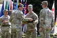 Col. Sean Heidgerken and Command Sgt. Maj. Avery Bennett, the 1st Theater Information Advantage Detachment command team, uncase the unit guidon as part of the unit’s activation ceremony November 7, 2025, at Fort Shafter, Hawaii.
