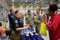 Two employees from the Sherriff's Office explain how to use life-saving tools to Safety Day attendees.