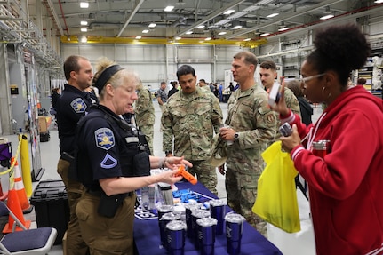 Two employees from the Sherriff's Office explain how to use life-saving tools to Safety Day attendees.
