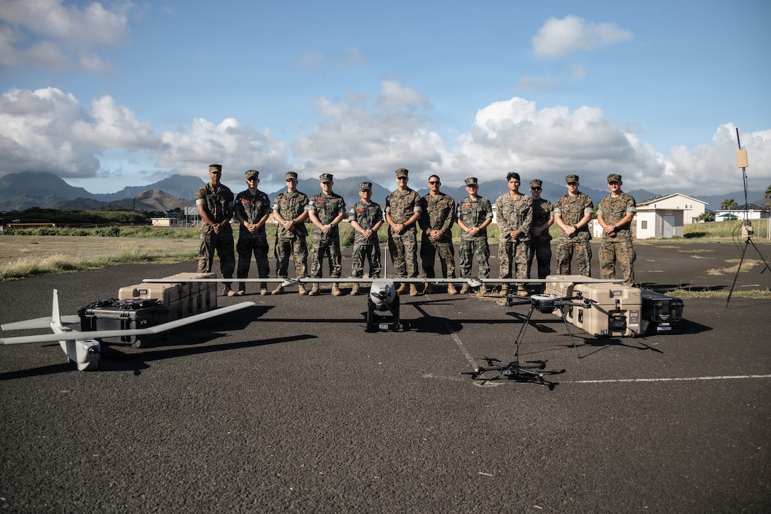 U.S. Marines with 3rd Marine Littoral Regiment, 3rd Marine Division, pose for a photo with Republic of Korea Marines behind small unmanned aerial systems at Marine Corps Base Hawaii, Oct. 29, 2025. This demonstration allowed the U.S. and ROK Marines to integrate their skills and strengthen interoperability by showcasing various payload attachments on several sUAS platforms. (U.S. Marine Corps photo by Sgt. Grace Barneveld)