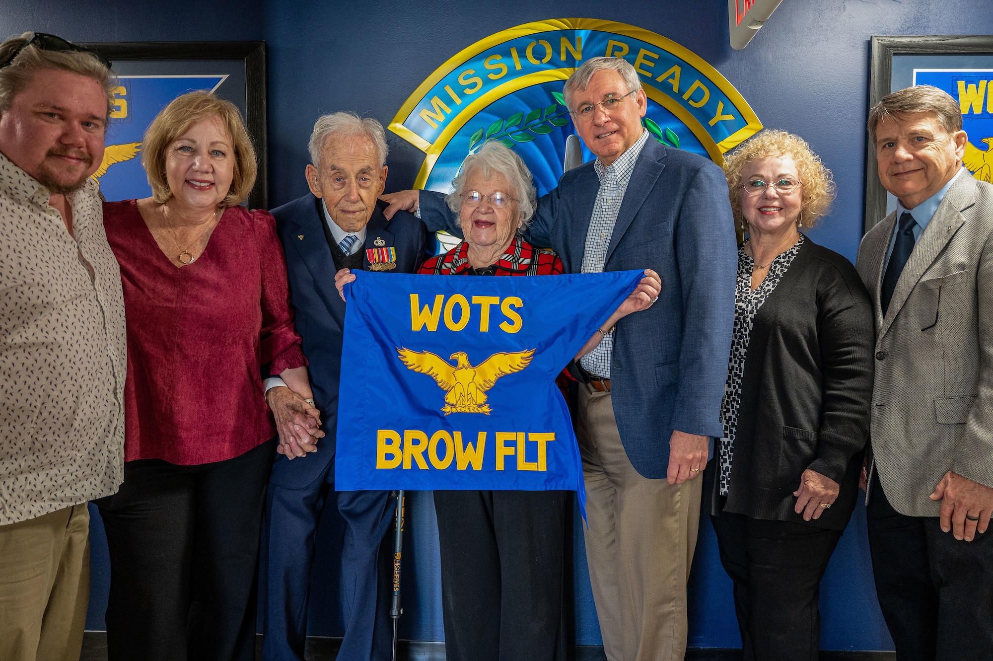 Retired U.S. Air Force Chief Warrant Officer 4 Robert Brow and his family pose for a photograph with the newly presented Brow Flight pennant at Maxwell Air Force Base, Alabama, Nov. 5, 2025.