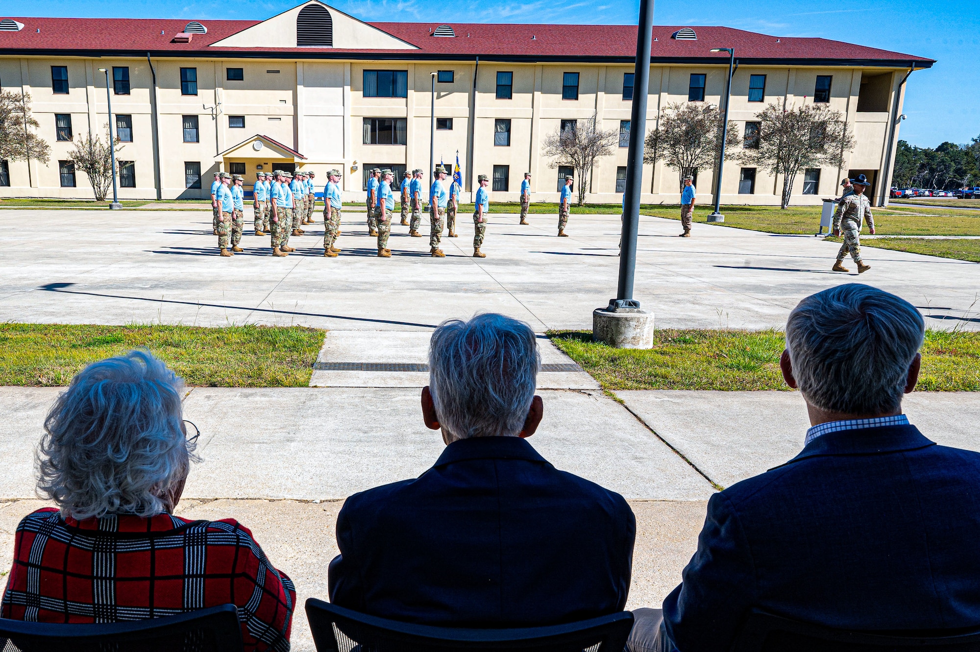 Karen Brow, wife, left, and retired U.S. Air Force Chief Warrant Officer 4 Robert Brow, center, and Robert E. Moriarty, right, Headquarters Air Force Deputy Assistant Secretary of the Air Force for Installations, watch warrant officer candidates from Class 26-02 during a guidon dedication ceremony at Maxwell Air Force Base, Alabama, Nov. 5, 2025.