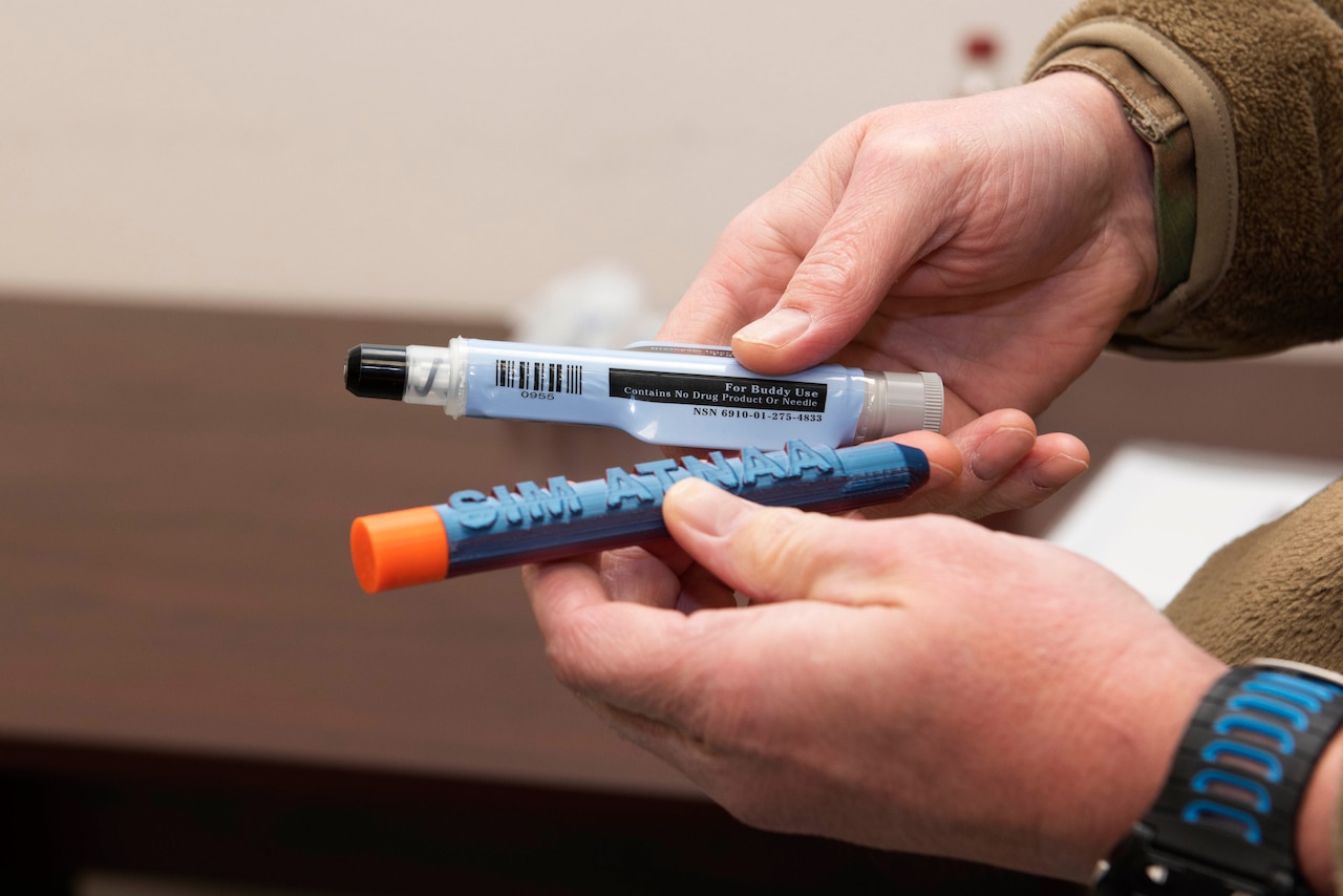 A set of hands holds two small cylindrical barrels.