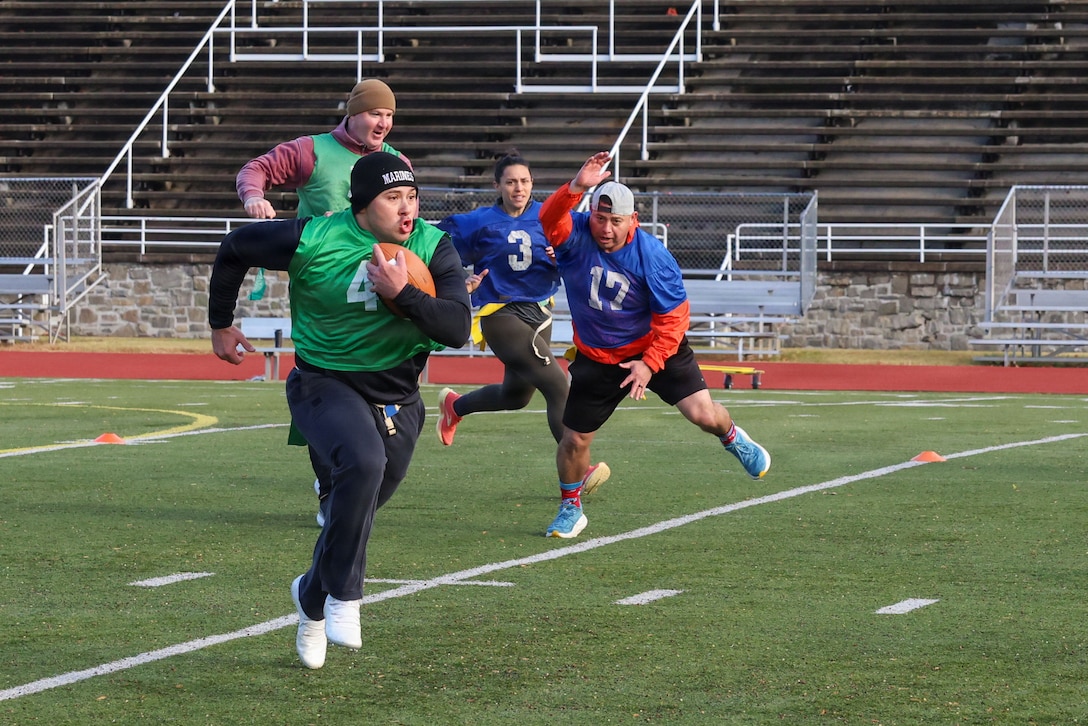 U.S. Marines and civilians with Marine Corps Recruiting Command play flag football during the 10th annual Turkey Bowl at Butler Stadium on Marine Corps Base Quantico, Va., Nov. 19, 2025. The Turkey Bowl is held before Thanksgiving to celebrate friendly competition and camaraderie, featuring a flag football game followed by a potluck lunch. (U.S. Marine Corps photo by Cpl. Brenna Ritchie)